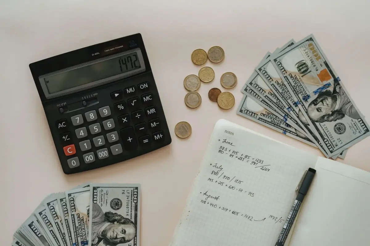 man calculates cost of kitchen remodel with notes and calculator