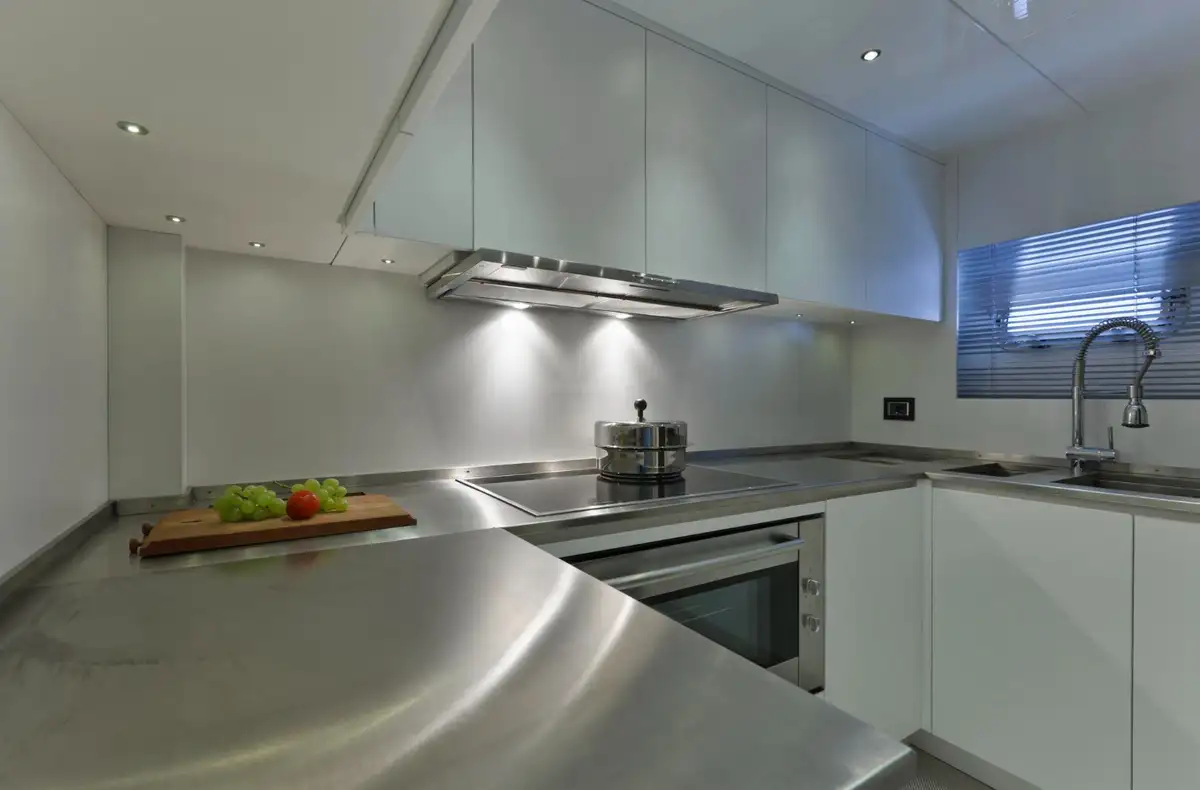 dark kitchen with steel countertop and small windows