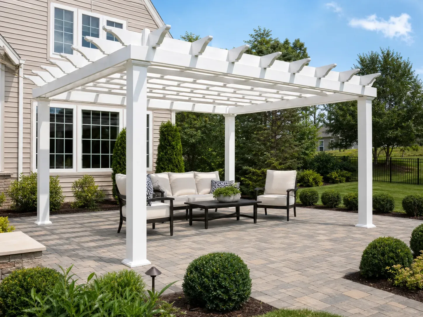 Clean white vinyl pergola over a paver patio in a suburban backyard