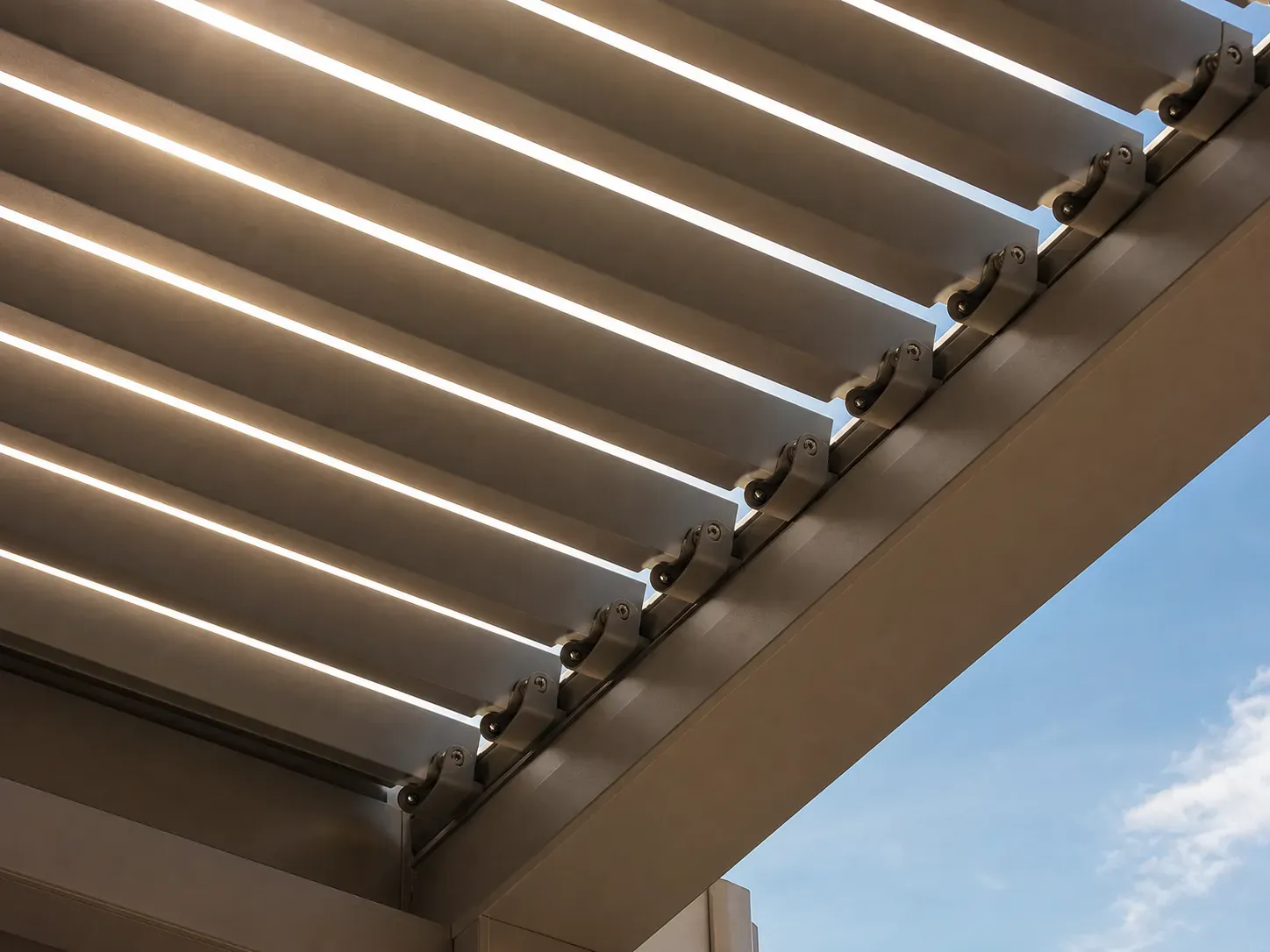 Close-up of adjustable aluminum louvered pergola roof slats with sunlight through the gaps