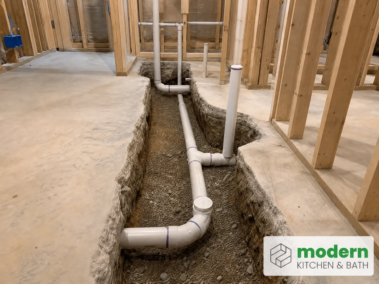 Basement bathroom rough-in with drain lines in a cut concrete slab